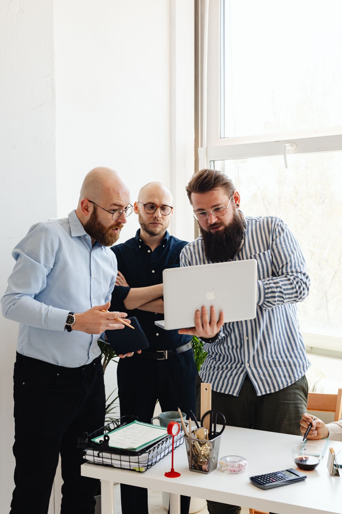 Source photo of business professionals collaborating around a laptop